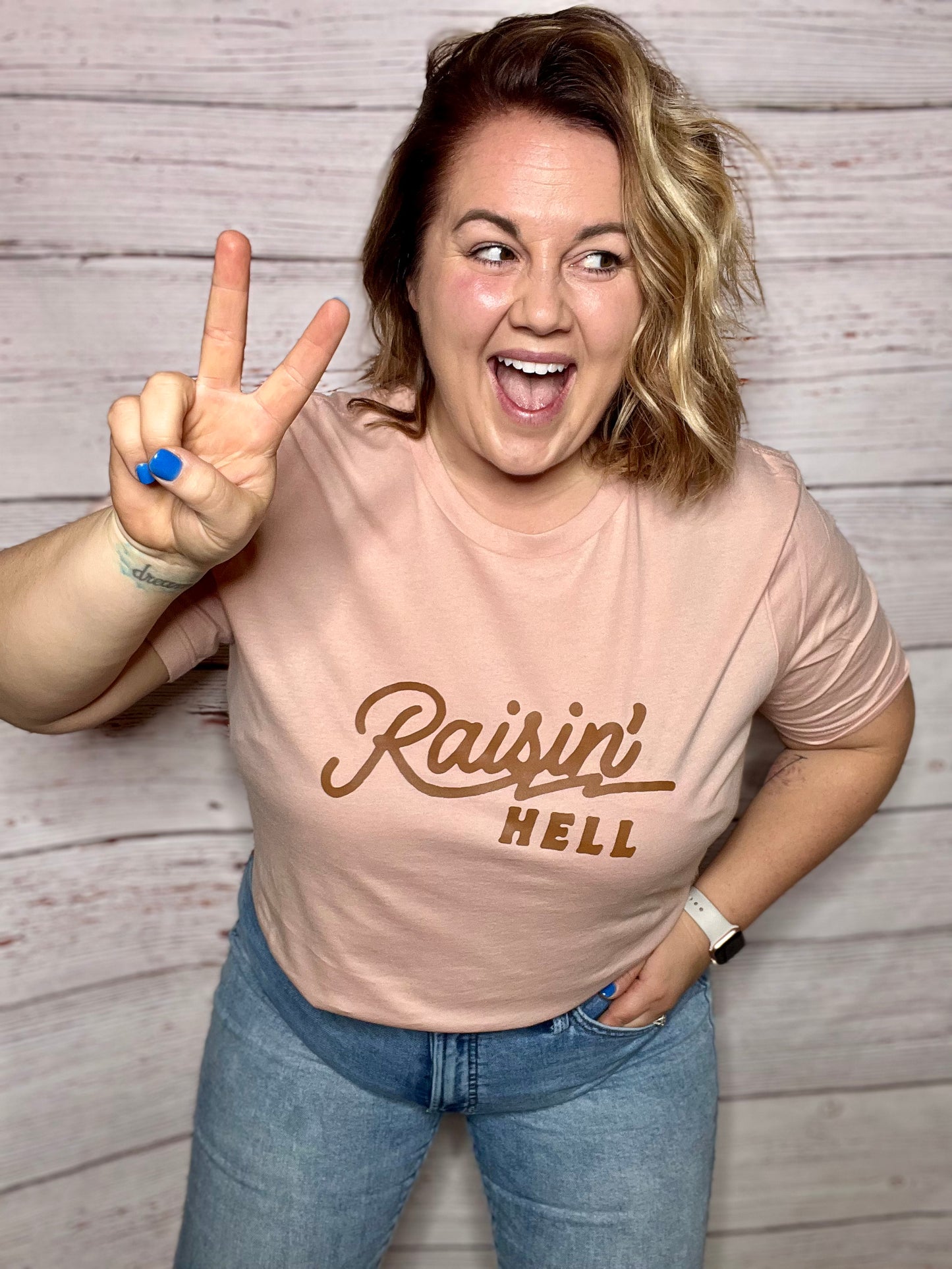 RAISIN' HELL (BROWN INK) Unisex T-shirt in PEACH